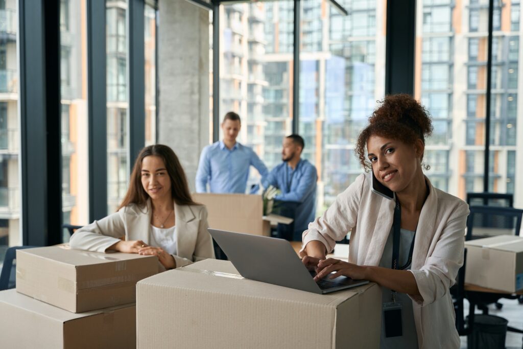 Pleased corporate employee and her coworkers conducting office move